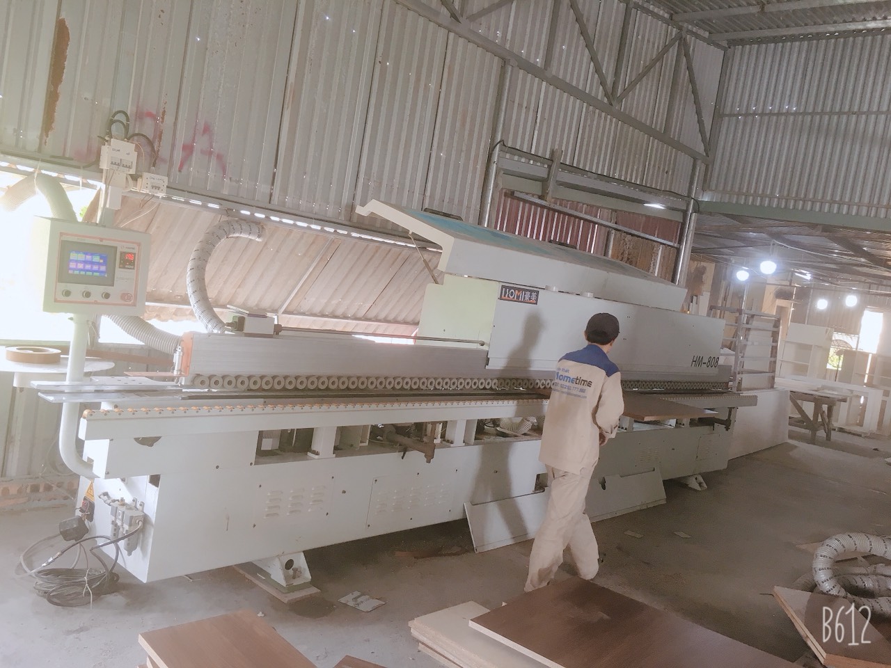 Người thợ đang thao tác trên chiếc máy dán cạnh bán tự động